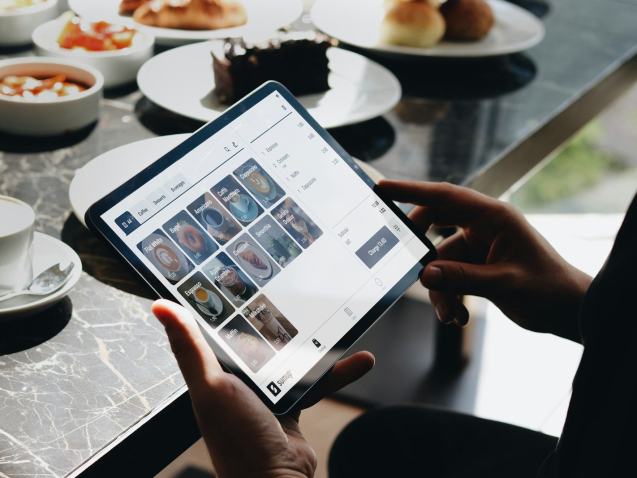 A person sitting at a table with a tablet